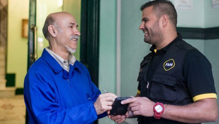 Portero de comunidad firmando contento la asistencia del Técnico FAIN de inspección