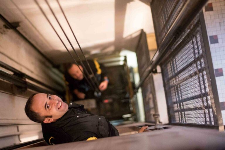 Técnicos de FAIN sonriendo revisando el estado de ascensor por dentro
