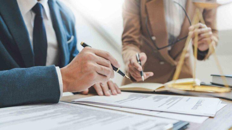 Dos personas firmando documentos legales