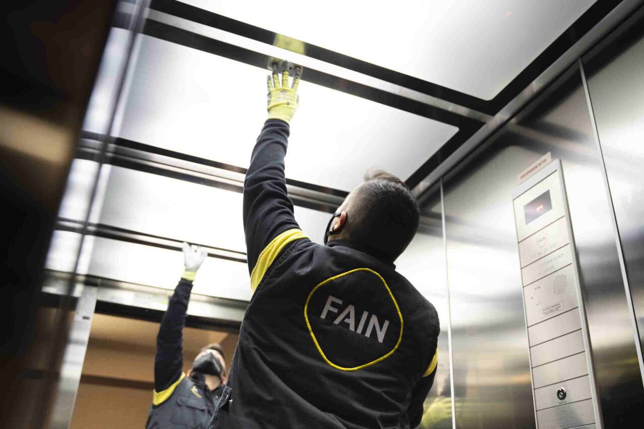 Técnico FAIN reparando ascensor metálico FAIN