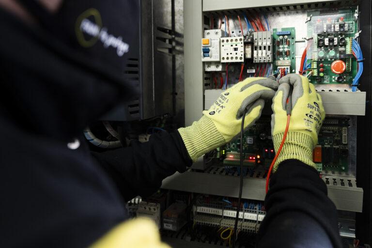 Técnico FAIN arreglando cables y máquinas en relación con deterioro ascensor