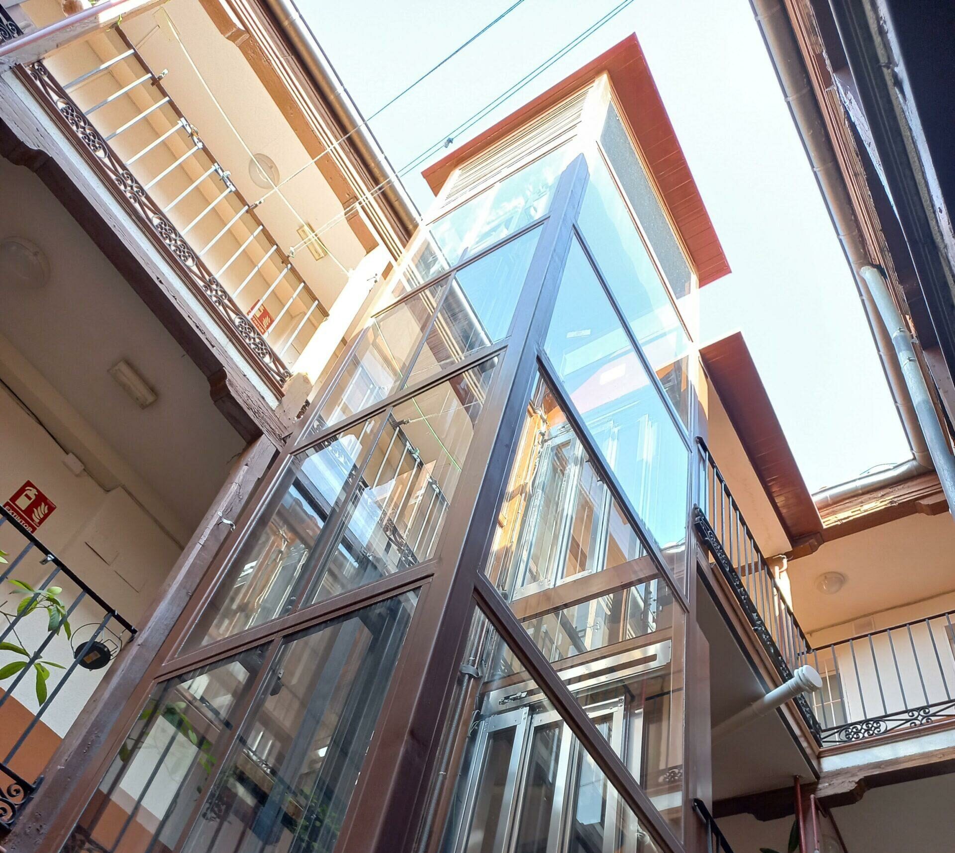 Ascensor con cristaleras en patio interior