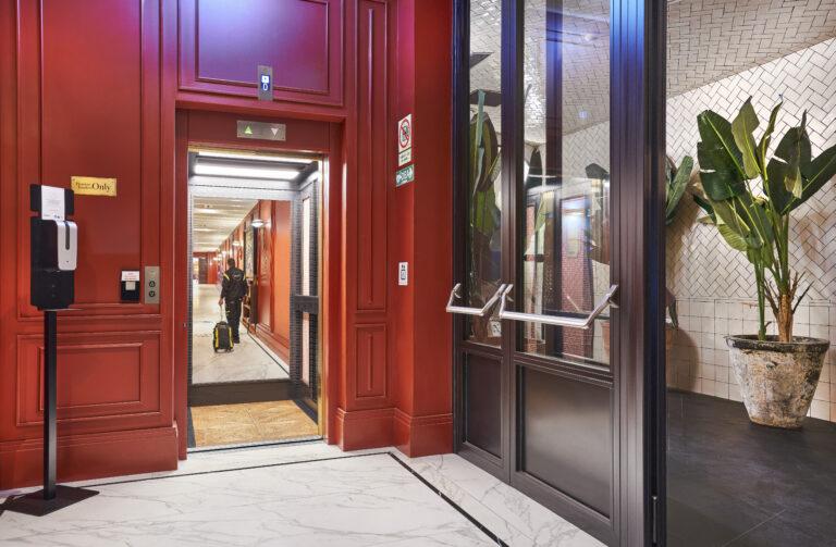 Técnico de mantenimiento yéndose tras terminar de reparar un ascensor histórico hotel Bless