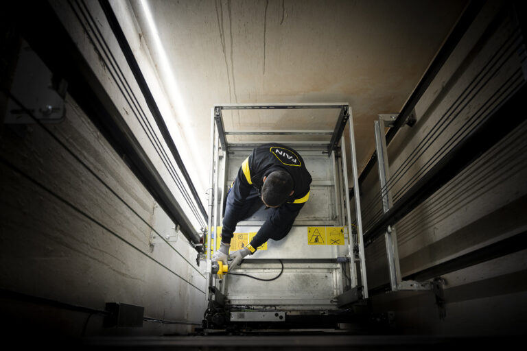 Técnico de mantenimiento de ascensores FAIN arreglando parte exterior ascensor