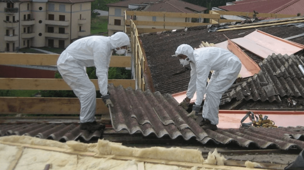 Trabajadores retirando amianto de una cubierta